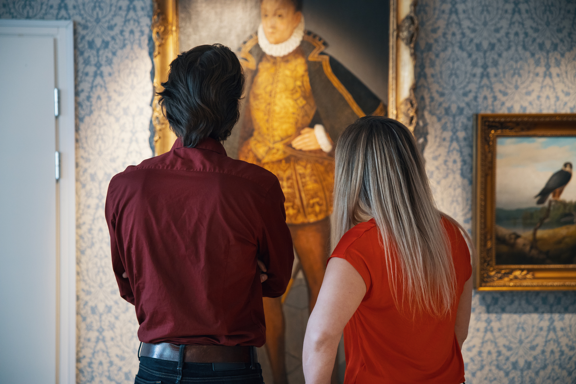 Kaksi henkilöä katsoo muotokuvaa museossa.