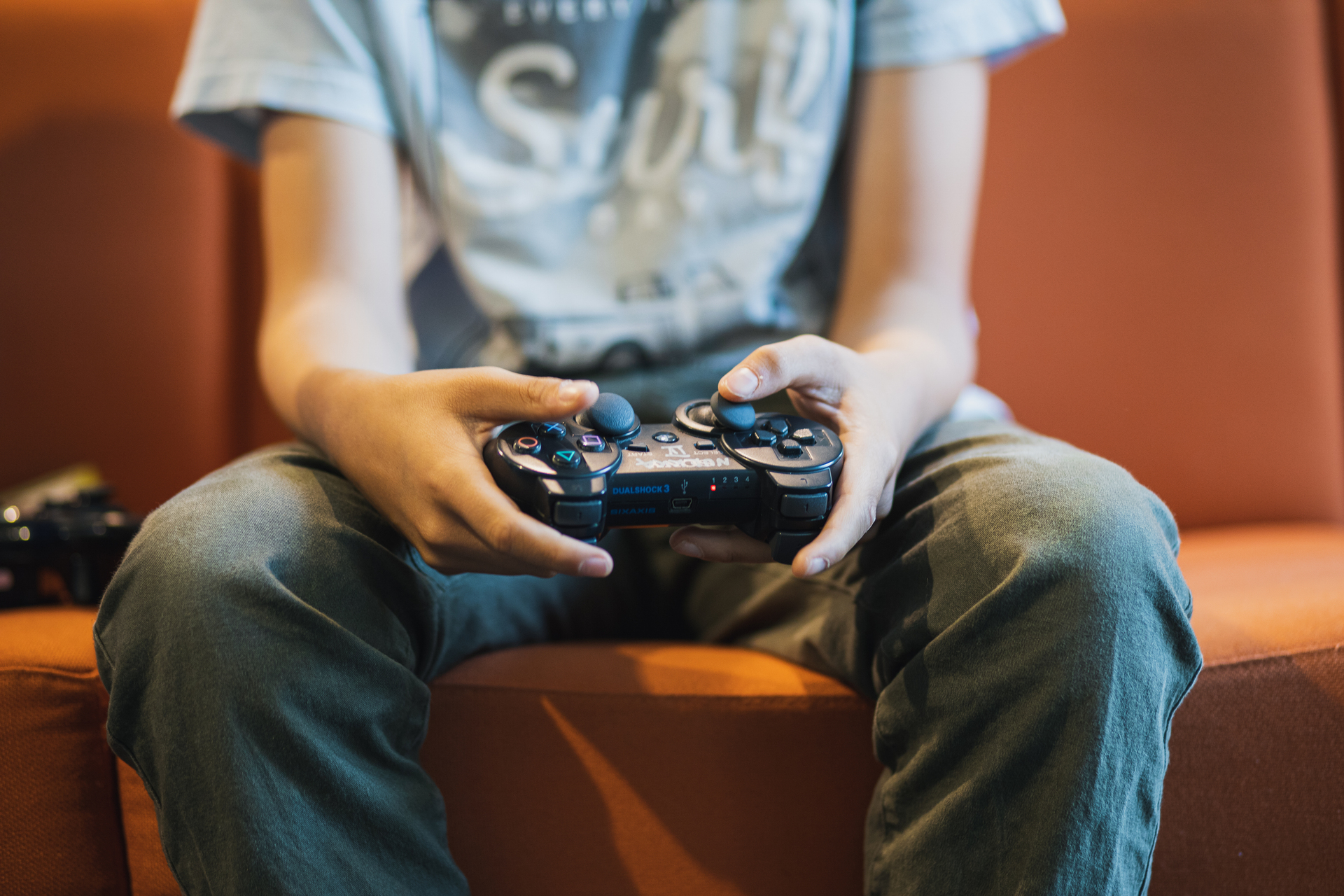Lapsi pelaa Playstationilla kirjastossa.