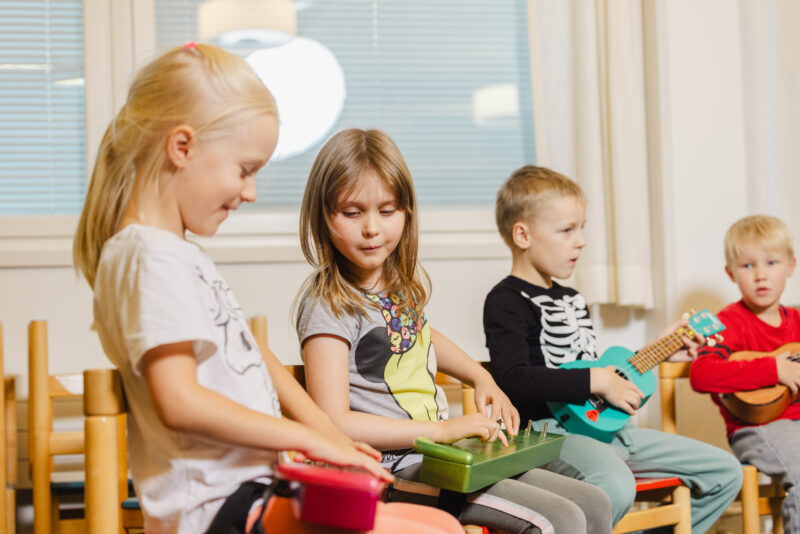 Children playing the kantele and the ukulele.