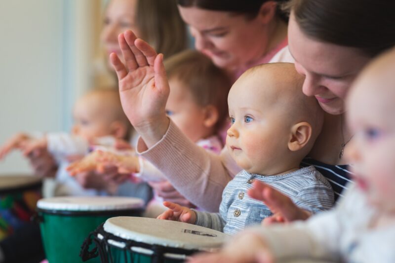 Kuvassa lapsia ja vanhempia soittamassa yhdessä djembe-rumpuja.
