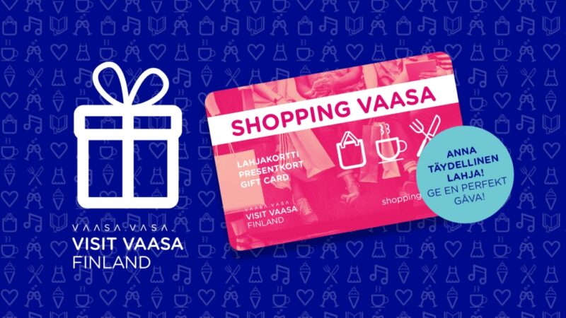 A gift card with 'Shopping Vaasa' written on it is shown against a blue background. The card has icons of a shopping bag and utensils. Text: 'Give a perfect gift!'