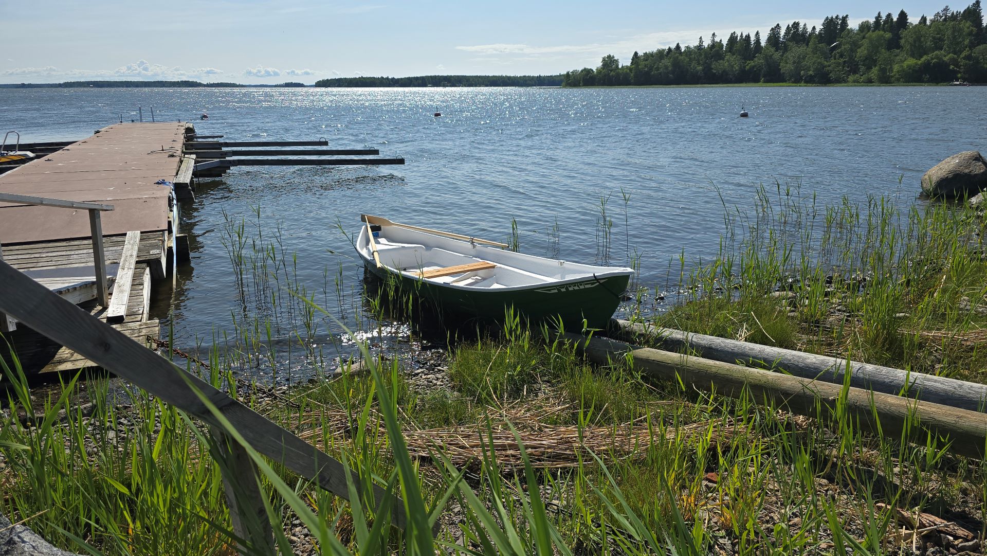 Lainattava soutuvene Ukkokarin rannan kaislikossa aurinkoisena päivänä.